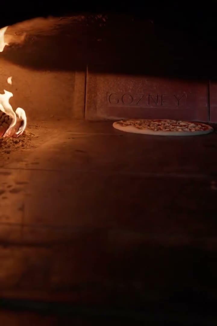 Nonnos Pizza — pizza going into the wood-fired oven